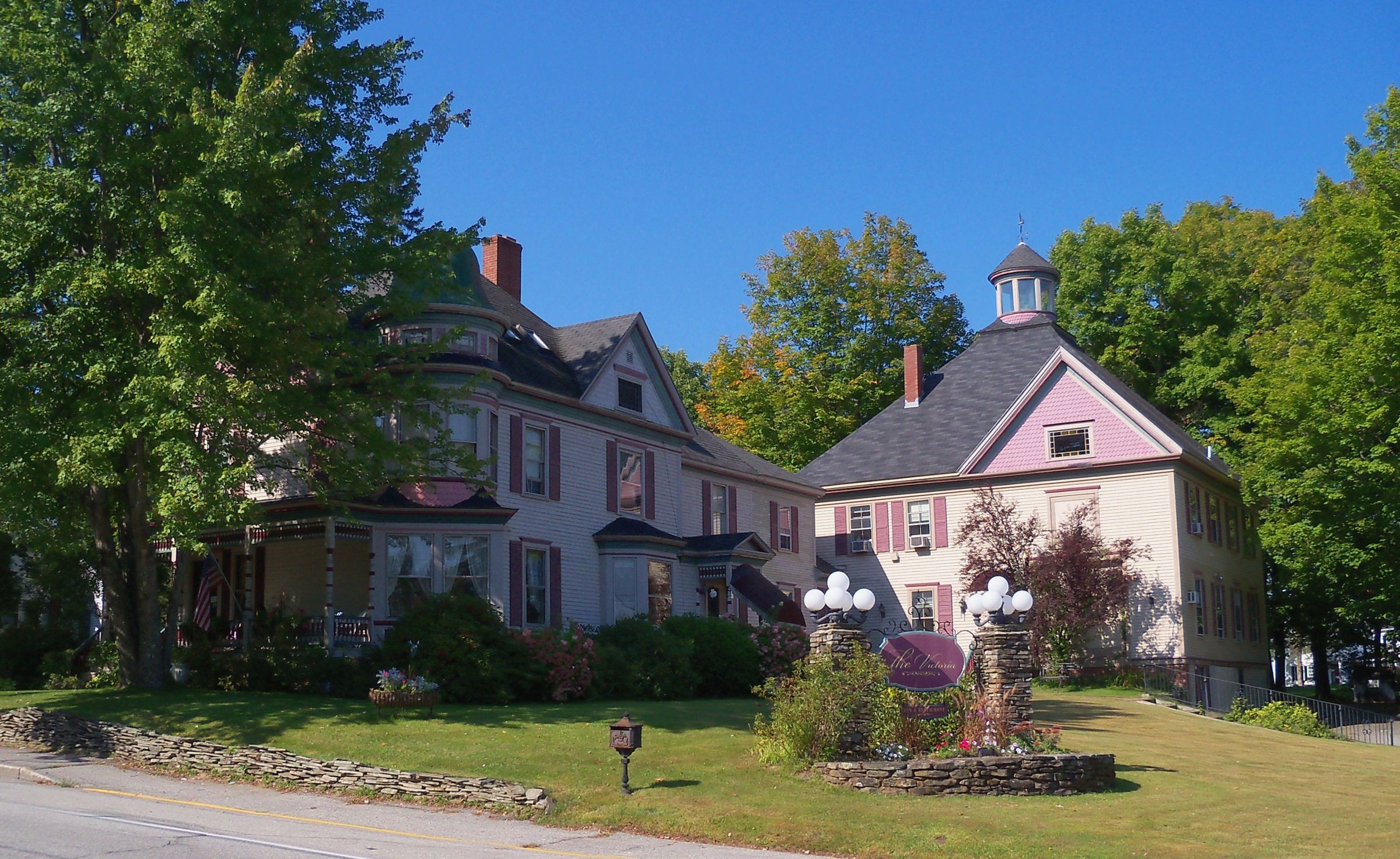 A Victorian inn with a wide front porch on a summer day